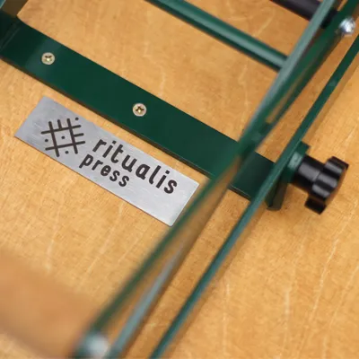 Linocut printing press main wooden desk with branding Ritualis Press.