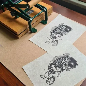 Printed papers with graphic by community members of Ritualis Press linocut printing press products.
