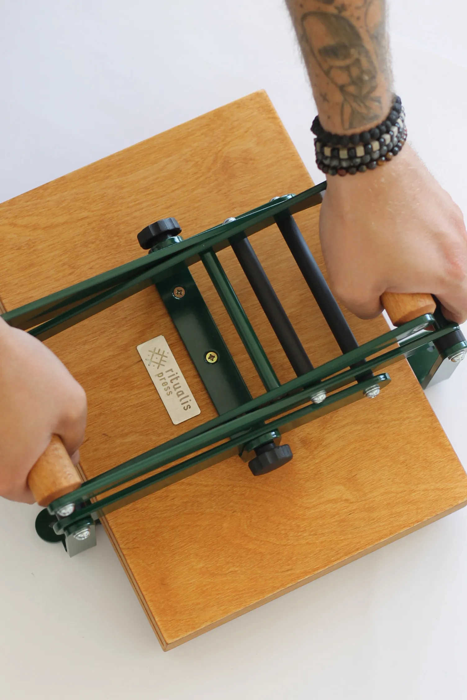 Two levers of wooden linocut printing press by Ritualis Press that are used to easily lean on the press with both hands.
